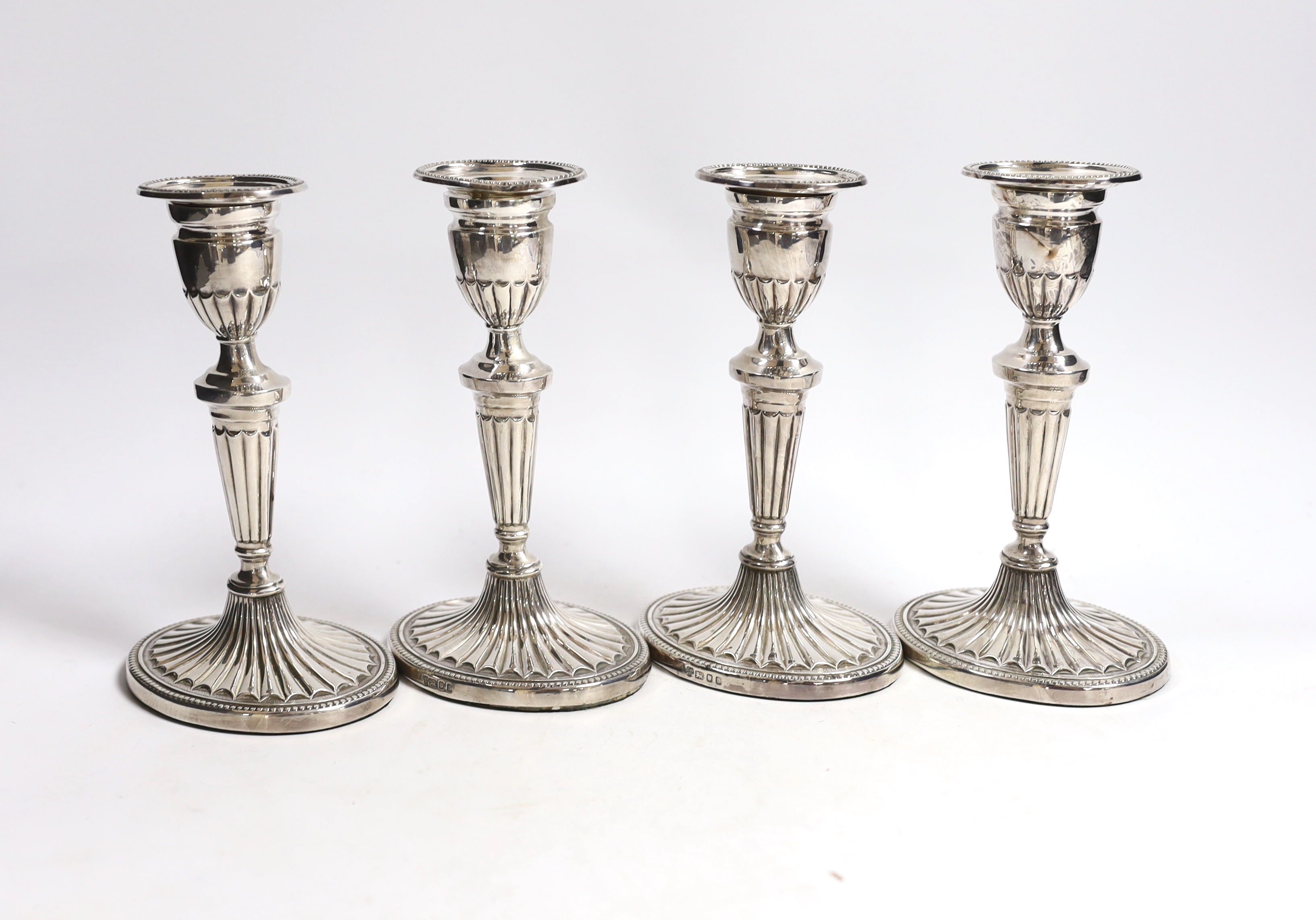 A set of four Elizabeth II silver candlesticks, with fluted stems and bases, C.J. Vander Ltd, London, 1973, 17.2cm, weighted.